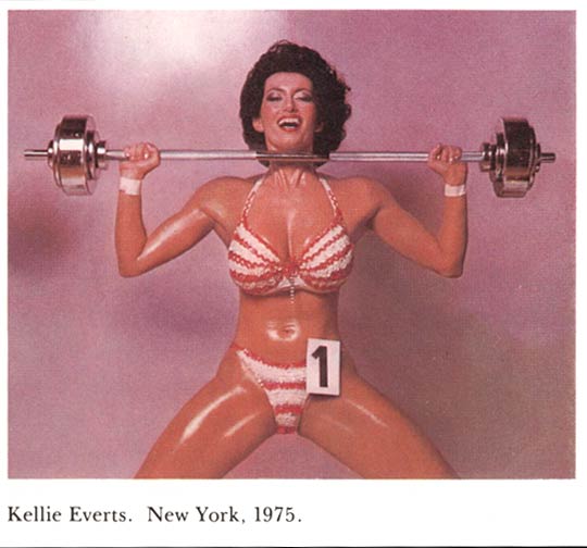 Female Body building. Kellie Everts, Brooklyn NY 1975. Woman lifting double barbell weights, rock hard bikini body glistening with oil and sweat. Photo appearing in Esquire taken by Jean-Paul Goude