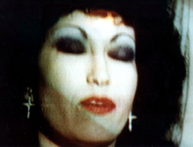 The Stripper for God with crucifix cross earring, eyes closed in thoughtful prayer
